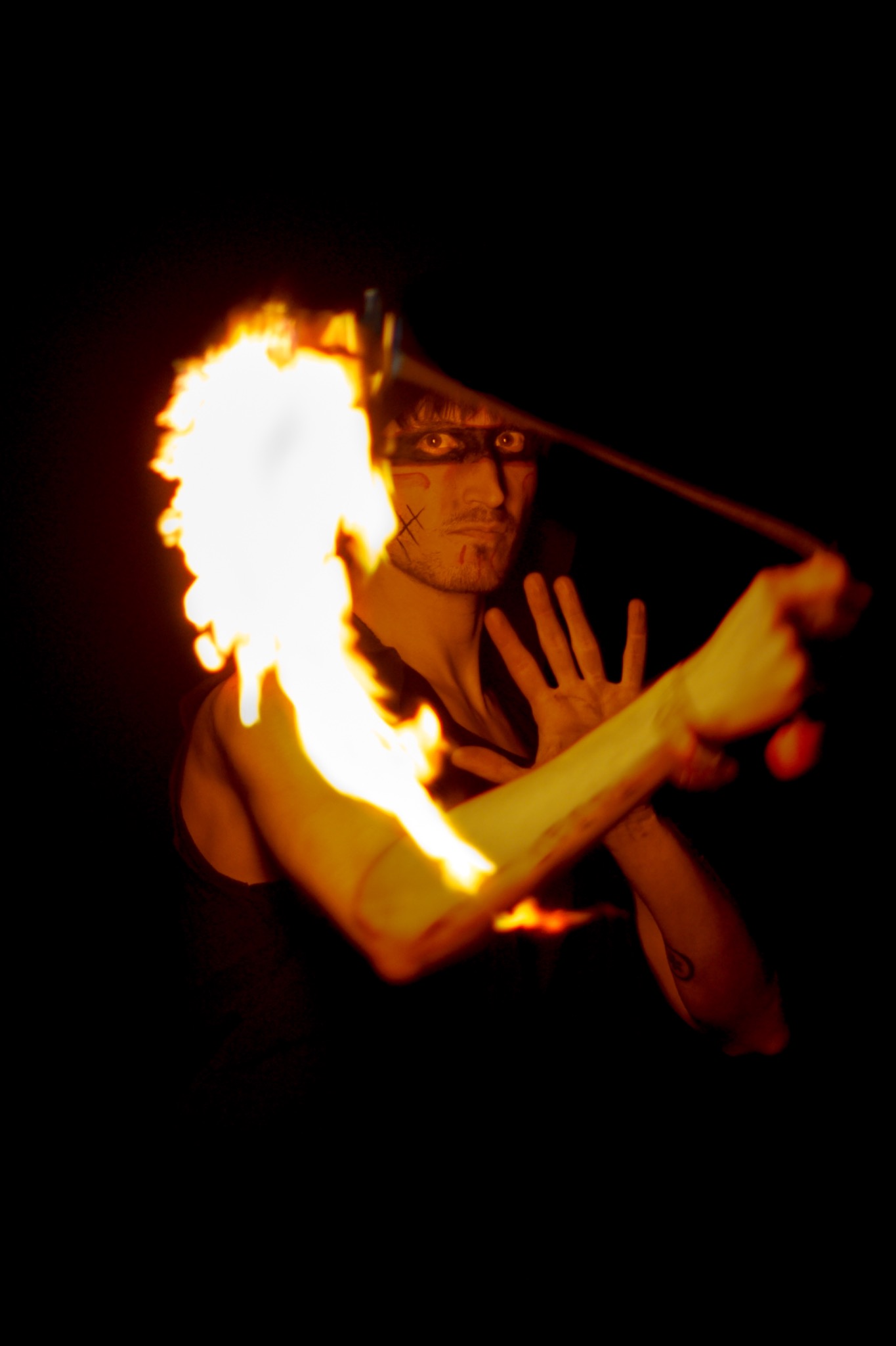 Performer with fire poi in darkness